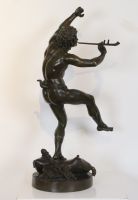 Faune dansant  Sculpture en bronze à patine brune, représentant un faune sur des attributs musicaux reposant sur une terrasse circulaire. 