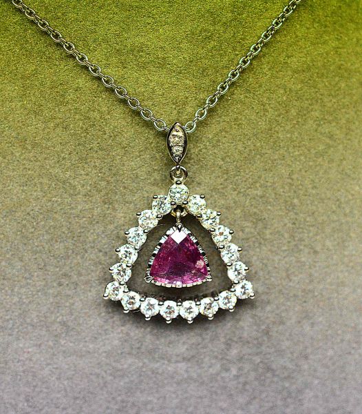 White gold pendant centered with a rare Natural Pink Sapphire of beautiful bright color weighing 1.03 c. Mounting enhanced with important extra white diamonds VS for 1.20 c approx. - Gold 5.90 g. 