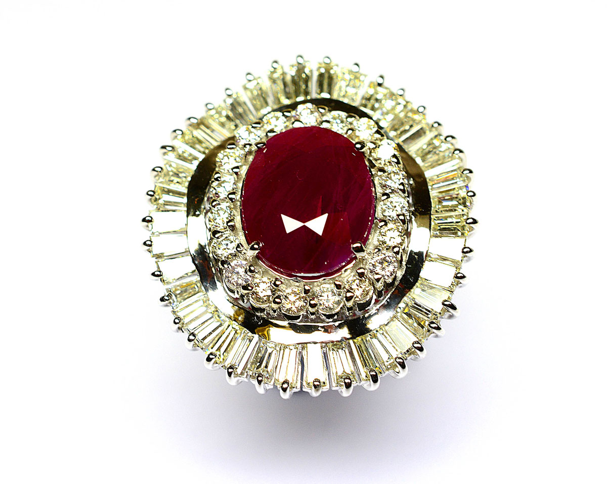 Important white gold skirt ring holding a natural oval Burmese ruby weighing 6.11 c in a surround of round and baguette diamonds for 3 c approx of beautiful quality - Gold 12.02 g. 