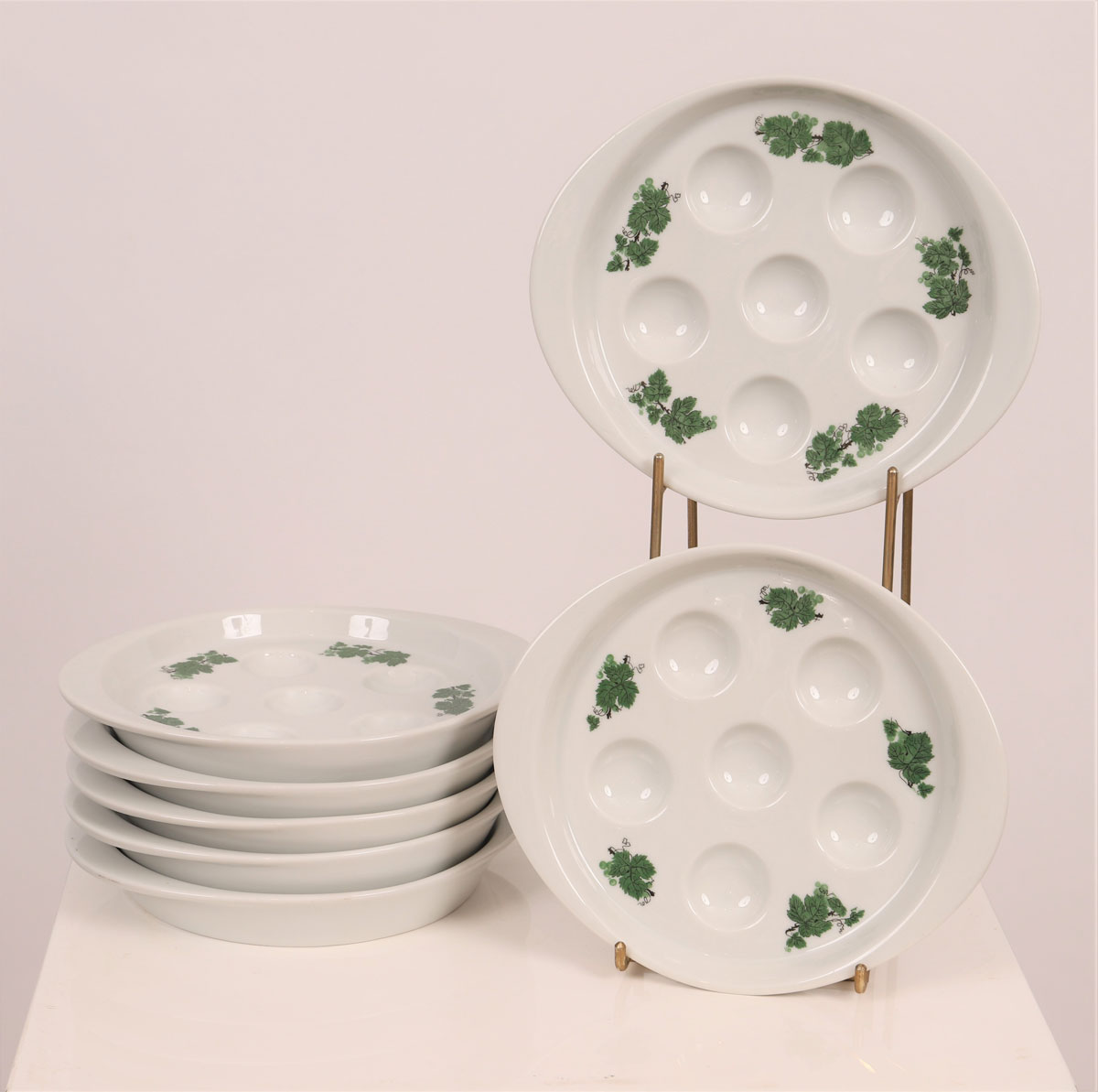 Seven snail plates, decorated with painted vine leaves.