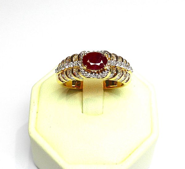 Yellow gold ring set with an oval ruby of good colour weighing 1.10 c. approx. - ring enhanced with baguette and round diamonds for 1 c. approx. - Gold 8.34 g.