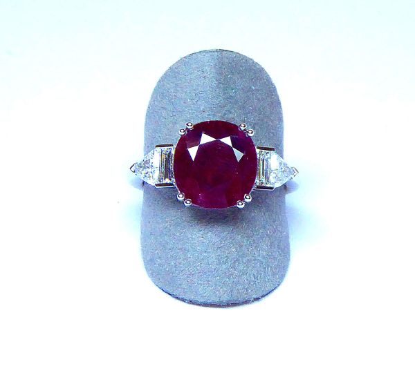 Bague en or blanc centrée d'un rubis NATUREL coussin probablement Birman pour 3,54c. au rouge intense et lumineux. Anneau rehaussé de 2 diamants baguettes et de deux diamants troïdia qualité G/VS - Or 3,47 g. 