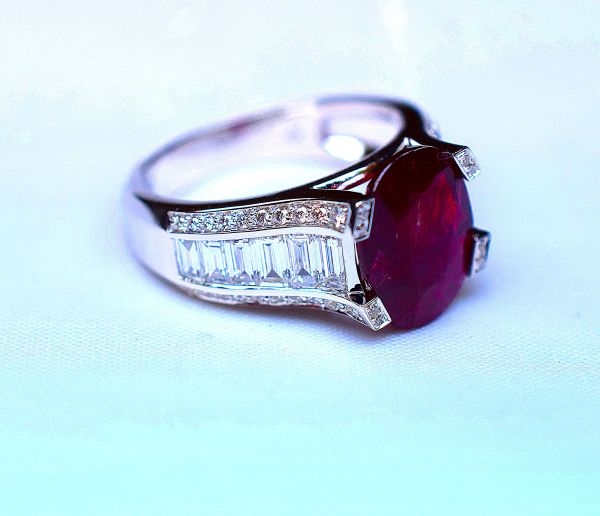 White gold ring set with 4 claws of a natural unheated oval ruby, probably Burmese, for 3.93 c, the setting being enhanced by a fall of baguette diamonds underlined by round diamonds G/VS for 2 c approx. in total - Gold 6,39 g.