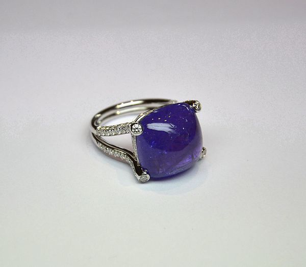 White gold ring set with a rare and important natural cushion-cut tanzanite cabochon for 24,54 c. Setting and stylized claws set with diamonds for 1,40 c G/VS - Gold 8,02 g. 