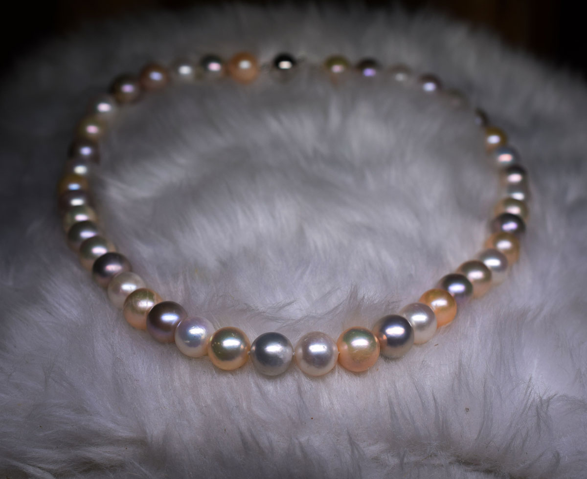 Important necklace of natural cultured pearls (D: 9,5 - 10 mm) in natural multicolored lilac, white and salmon colors, with a very pleasant luster. Gold clasp