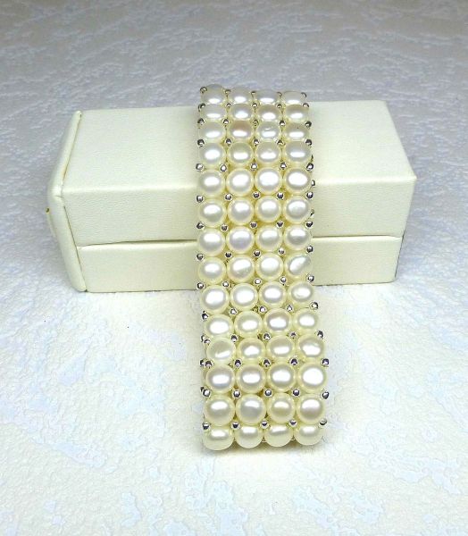 Bracelet with four rows of natural cultured pearls (D: 6 mm) mounted on elastic and decorated with silver motifs