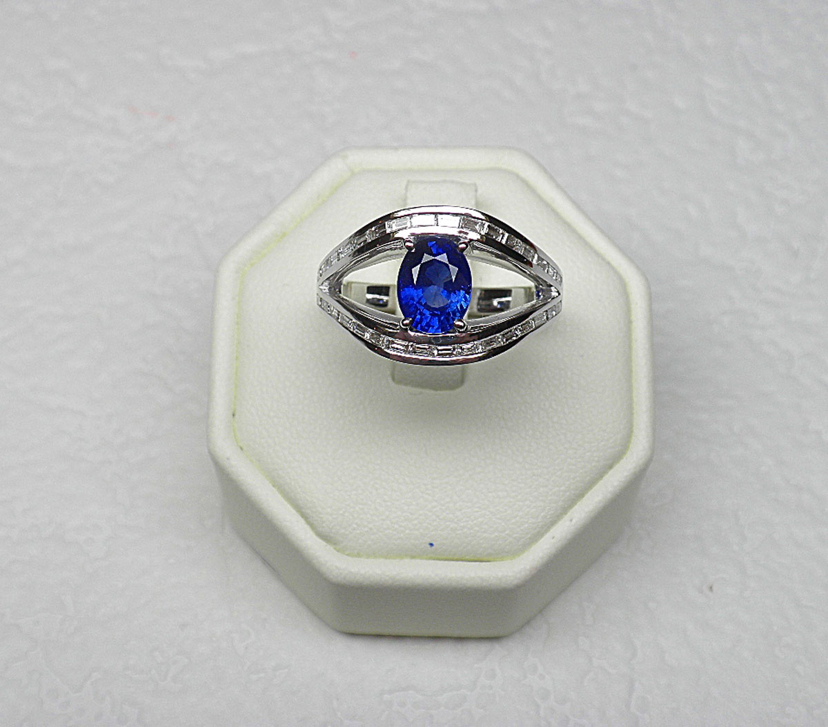 Ring in white gold with a double ring set with 32 baguette diamonds G/VS for 1 c. approx. supporting an oval Ceylon sapphire of very beautiful colour for 2 c. approx. - Gold 5,40 g.