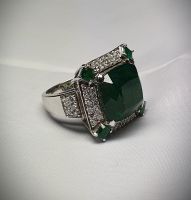 Important white gold ring set with 4 claws of a degree emerald probably Colombia weighing 16.59 c in a surround of modern round diamonds, enhanced at the 4 corners with square emeralds. Weight of the diamonds 1.50 c approx. G/VS quality. - Gold 16,19 g