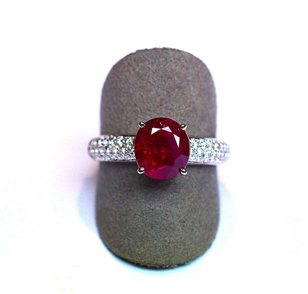 Bague jonc en or blanc centrée d'un rubis oval Naturel Birman au très beau rouge lumineux pesant 2,50 c, monture pavée de 44 diamants ronds taille brillant G/VS - Or 3,72 g. 