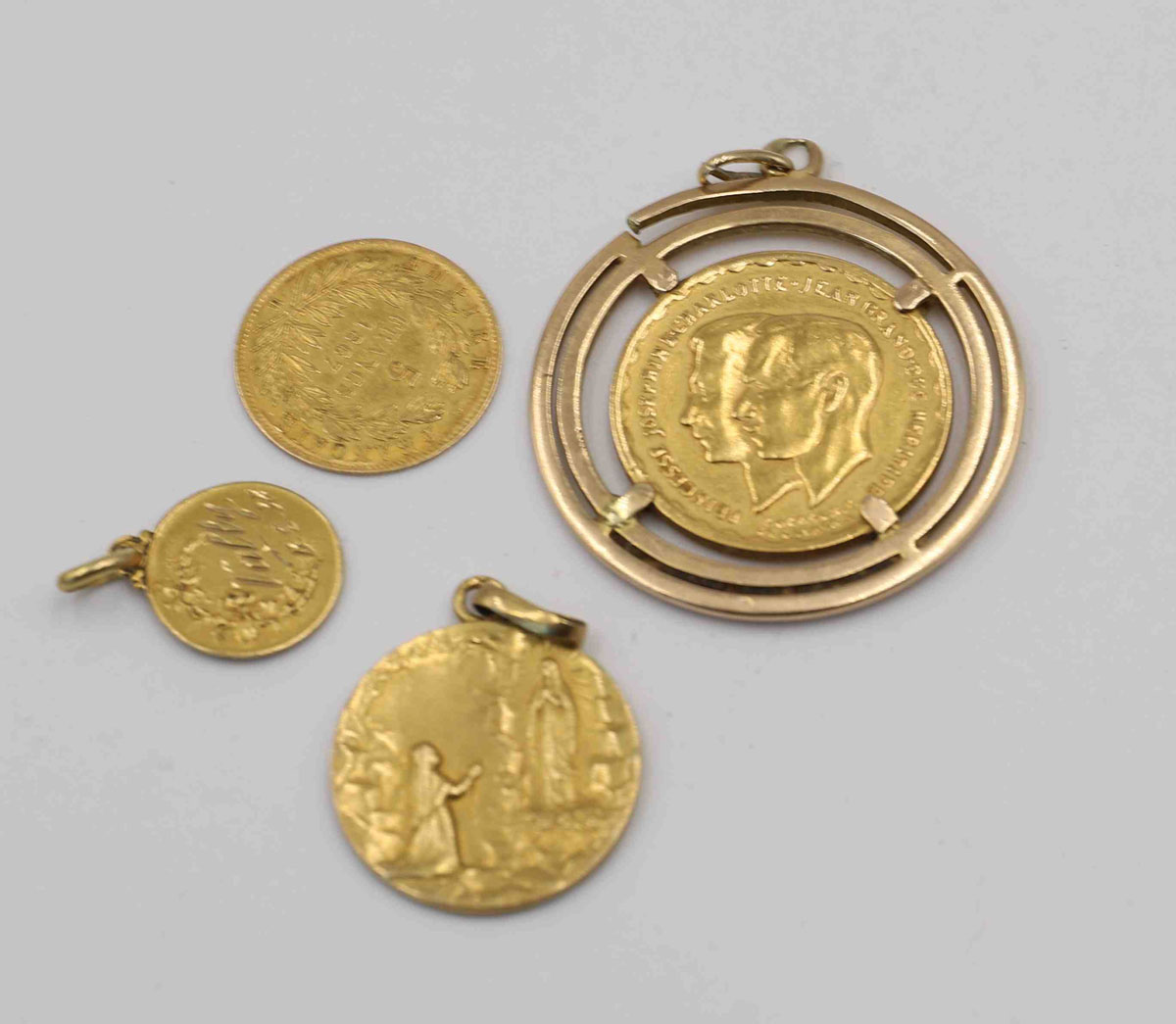 Lot d'Or composé d'une pièce à l'effigie du Grand-Duc Jean et de la Grande-Duchesse Charlotte de Luxembourg, une pièce de 5Francs Napoléon III et de deux médailles de baptême religieux.